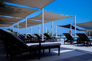 A poolside area with lounge chairs and umbrellas. - Crowne Plaza Sohar (Sohar)