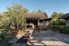 A traditional Japanese-style house with a wooden porch, a gravel pathway, and a garden with various plants. - The Moment Hotel Yilan by Lakeshore (Wujie)