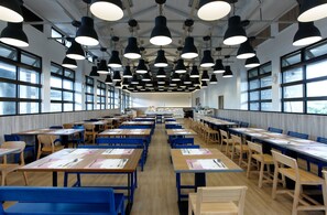 A spacious cafeteria with multiple tables and chairs, large windows, and pendant lighting. - The Moment Hotel Yilan by Lakeshore (Wujie)