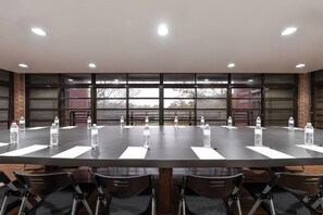 A conference room with a long table, chairs, and water bottles. - The Moment Hotel Yilan by Lakeshore (Wujie)