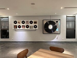 Habitació amb una col·lecció de discos penjada a la paret i un disc de vinil gran.