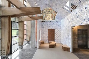 A modern interior with exposed wooden beams, patterned walls, and a central decorative element. - The Moment Hotel Yilan by Lakeshore (Wujie)