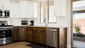 A modern kitchen with white cabinets, a stainless steel dishwasher, and a built-in oven. - Hyatt Home Pet Friendly! Community pool and hot tub! (Washington)