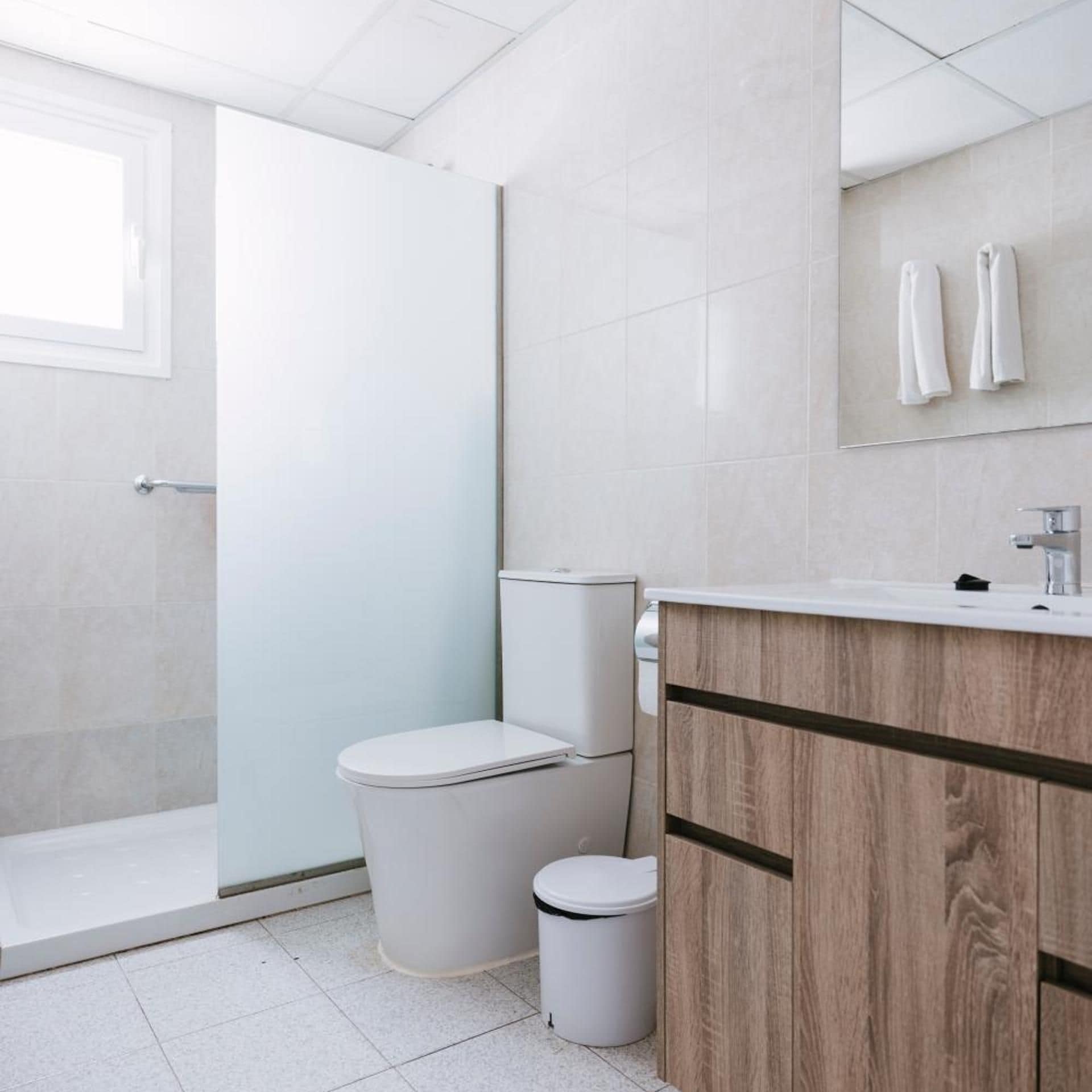 A modern bathroom with a toilet, bidet, and a shower area.