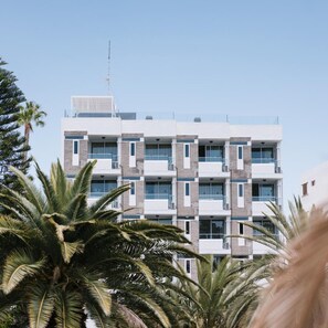Un immeuble à plusieurs étages doté d’une architecture moderne, avec des balcons et de grandes fenêtres.