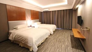A hotel room with two beds, a wooden headboard, a flat-screen TV, and a small wooden shelf. - J.S Fashion Hotel (Zhuhai)