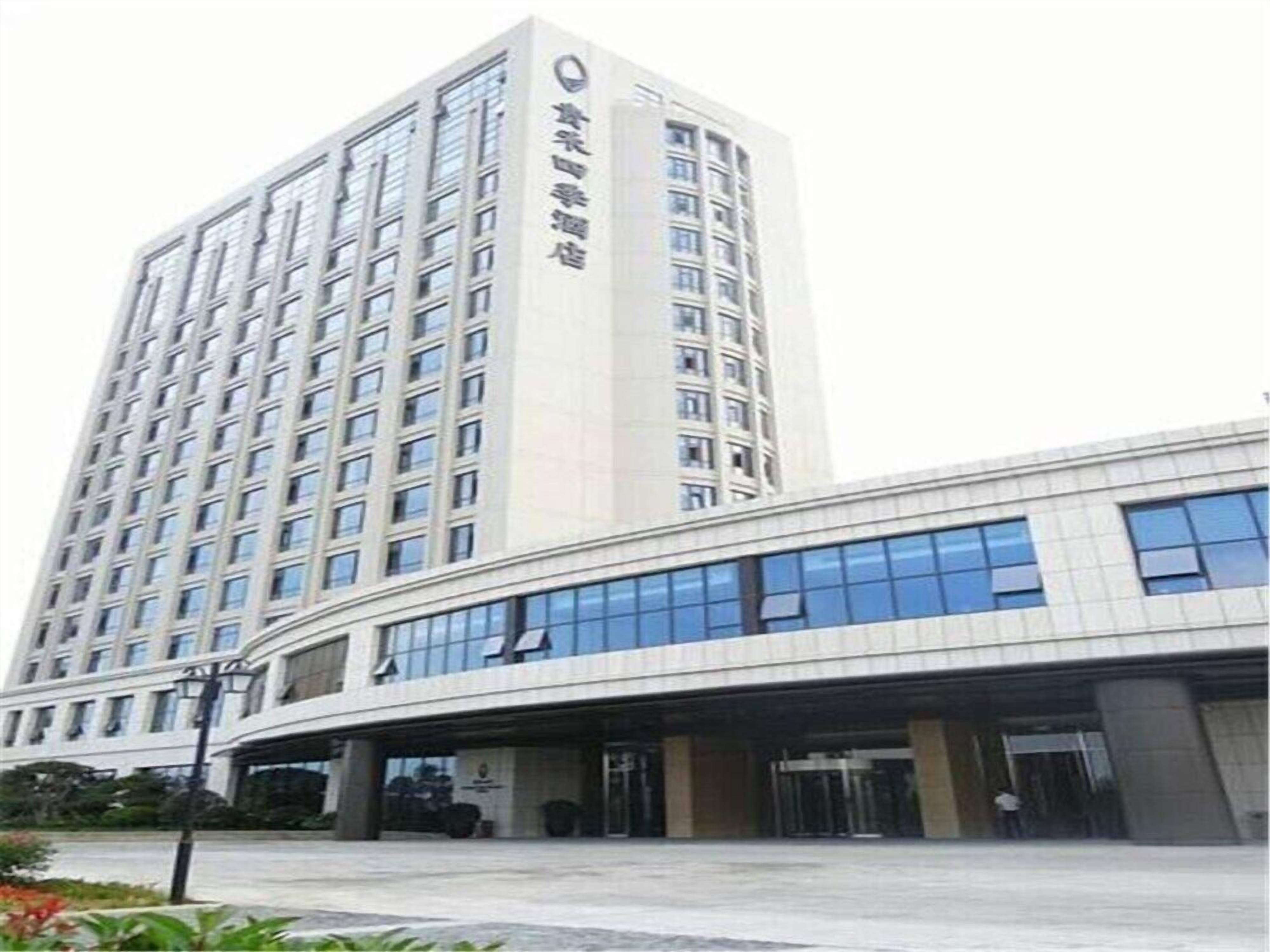 A modern hotel with a tall building and a curved entrance.