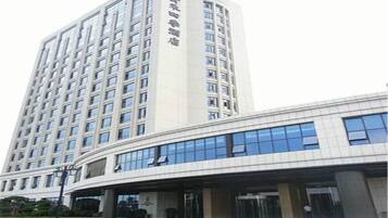 A modern hotel with a tall building and a curved entrance.