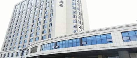 A modern hotel with a tall building and a curved entrance.