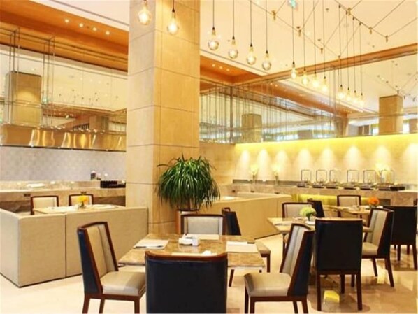 Un moderno vestíbulo de hotel con una zona de estar central, un mostrador de recepción y un bar.