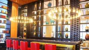A bar area with a long counter and red bar stools. - Guihe Siji Hotel Weihai (Weihai)