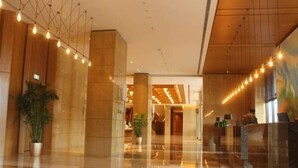 A spacious lobby with a polished floor, large pillars, and string lights. - Guihe Siji Hotel Weihai (Weihai)