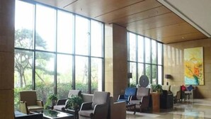 A spacious lobby with large windows, comfortable seating, and a modern design. - Guihe Siji Hotel Weihai (Weihai)