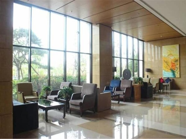 A spacious lobby with large windows, comfortable seating, and a modern design. - Guihe Siji Hotel Weihai (Weihai)