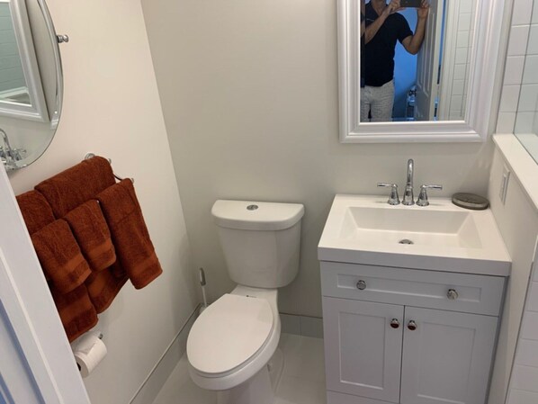 A bathroom with a toilet, sink, and towel rack.