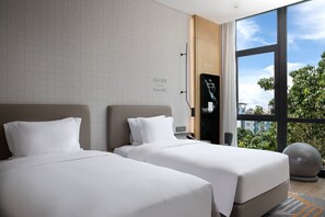 A hotel room with two beds, a large window with a city view, and a workout ball. - EVEN Hotel Shenzhen Nanshan by IHG (Shenzhen)