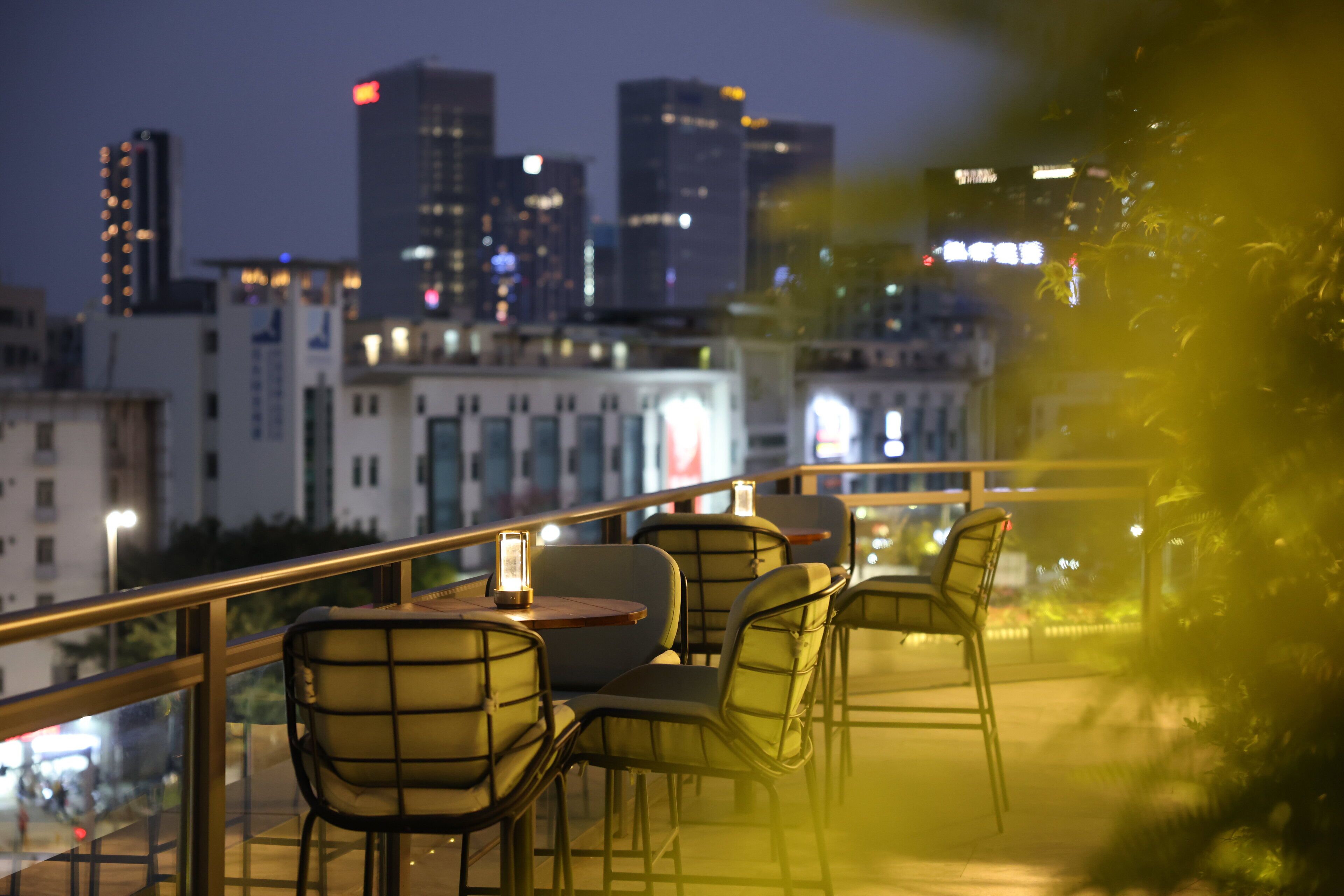 A terrace with outdoor seating and a city skyline in the background.