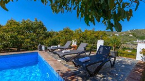 A swimming pool with lounge chairs and potted plants. - Villa Javier de Frigiliana by Ruralidays (Málaga)
