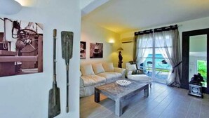 A living room with a sofa, coffee table, and artwork on the wall. - Miramare Park (Rhodes)