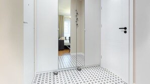 A room with a mirrored wardrobe, a patterned floor, and a door with a handle. - Modern Studio | Parking | Close to the Airport (Warszawa)