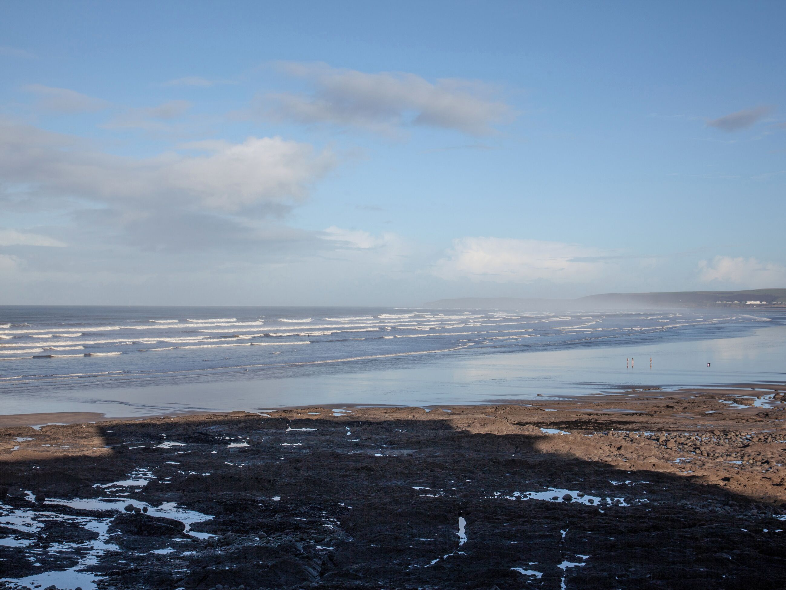 A coastal landscape with rocky terrain and a view of the ocean.