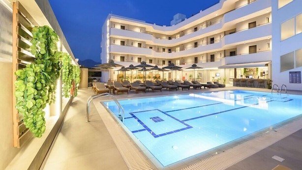 A modern hotel with a swimming pool, sun loungers, and a bar area. - Nicolas Grand Suites (Kos)
