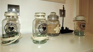 Four glass jars with labels on a white surface. - Stylish Private Double En-suite - 1 (London)