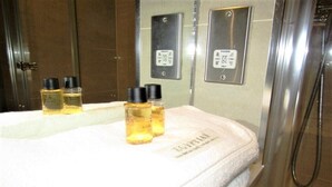 A bathroom with a white towel, a mirror, and three bottles of lotion on the counter. - Stylish Private Double En-suite - 1 (London)