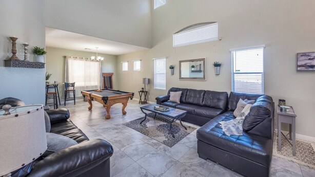 A spacious living room with a pool table, leather sofas, and a dining area with a table and chairs. - 777Rentals - 4BRs/3BA - Wet and Wild Convenience (Las Vegas)