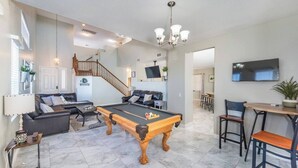 A spacious living area with a pool table, comfortable seating, a staircase, and a dining area. - 777Rentals - 4BRs/3BA - Wet and Wild Convenience (Las Vegas)