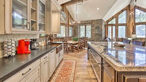 Una cocina con una isla grande, armarios de madera y una pared decorativa de piedra.