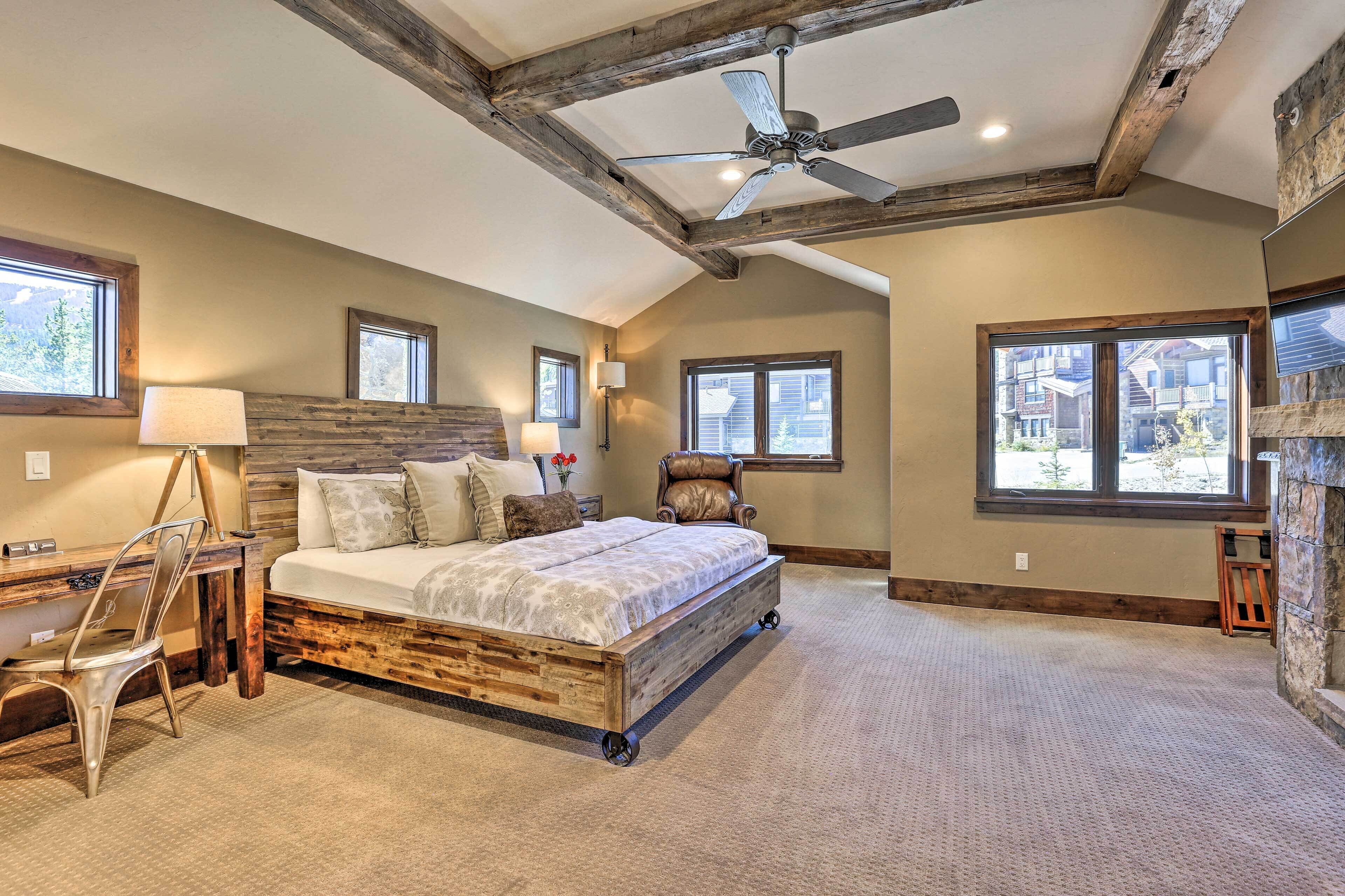 A bedroom with a wooden bed, a desk, a chair, and a ceiling fan.