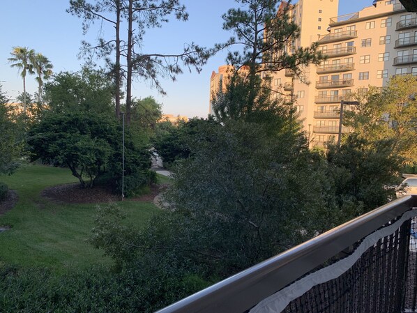 A residential area with a pathway leading to a gated entrance, surrounded by trees and a tall building in the background. - Universal Studios, International Dr (Orlando)