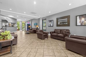 A spacious lobby with leather sofas, a reception desk, and framed artwork on the walls. - Universal Studios, International Dr (Orlando)