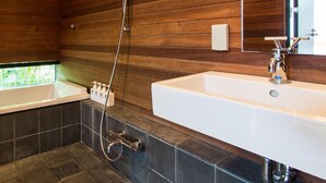 A modern bathroom with a bathtub, a separate shower area, and a sink.