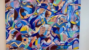 Une grande peinture abstraite orne un mur.