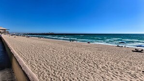 A wide sandy beach with a clear blue sky and calm sea. - Walk to Beach: Oceanfront Rocky Point Condo (Puerto Penasco)
