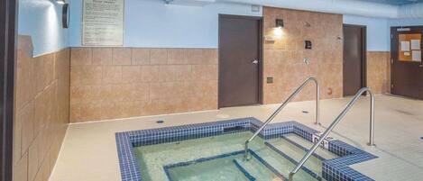 A hot tub area with tiled steps and a sign about hot tub rules.