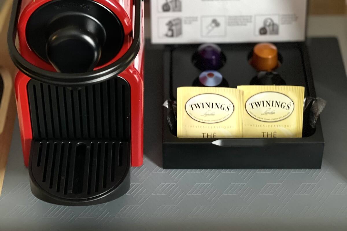 A coffee machine with a manual, two Twinings tea boxes, and a coffee preparation guide.
