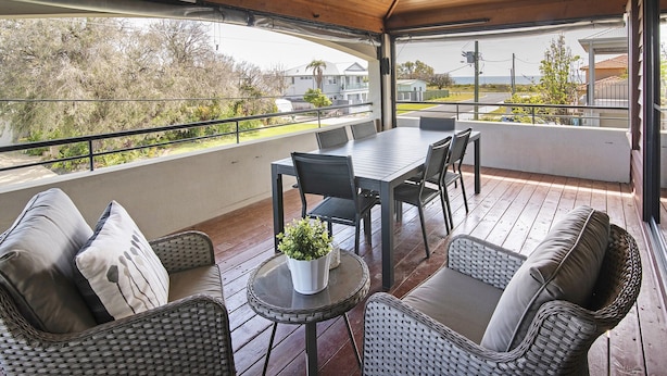 Eine Terrassengruppe mit Tisch und Stühlen, ein kleiner runder Tisch mit einer Pflanze sowie Korbm öbel.