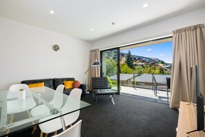 Deluxe appartement | Woonruimte | Een 32-inch flatscreentelevisie met kabelzenders en een televisie
