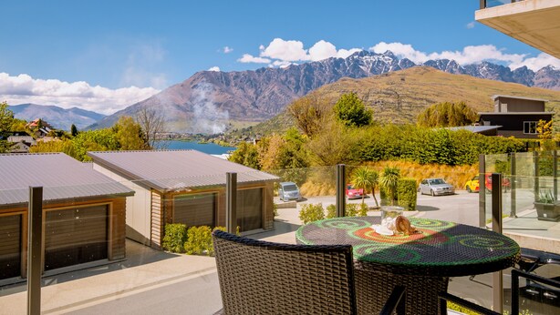 A modern outdoor seating area with a view of mountains and a lake. - Brookside Gem Modern 2 Bedroom Apartment (Queenstown)