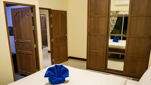 A hotel room with a bed, a wardrobe, and a mirror. - Villa Tanya at Platinum (Rawai)