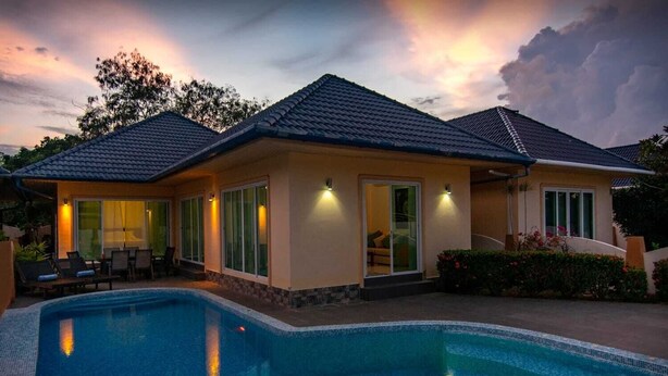 A modern house with a swimming pool, large windows, and a well-lit patio area. - Villa Tanya at Platinum (Rawai)