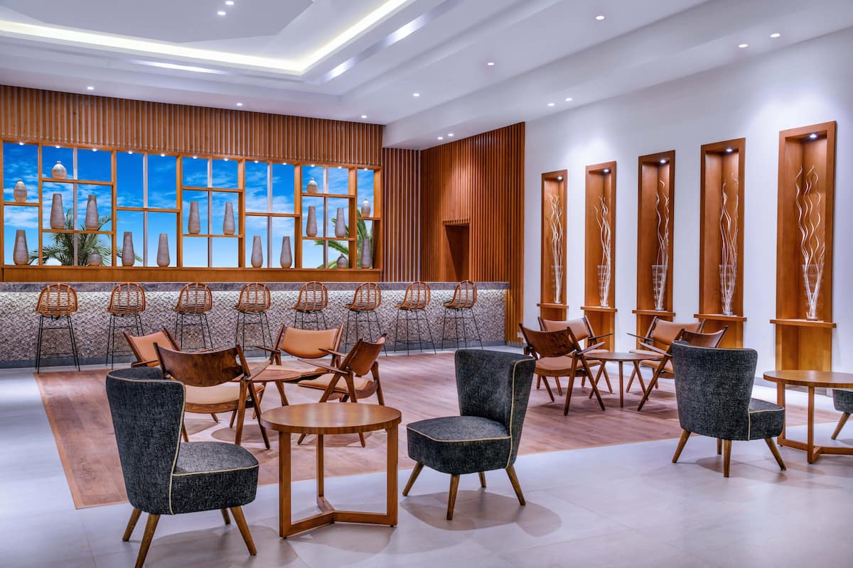 Eine moderne Lobby mit Holzverkleidung, einem großen Fenster mit Vasen und komfortablen Sitzgelegenheiten.