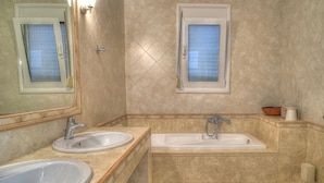 Une salle de bain avec deux éviers, une baignoire et des toilettes.