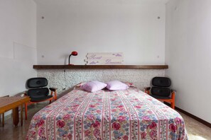 2 dormitorios y tabla de planchar con plancha