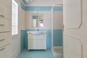 Ein Badezimmer mit Waschbecken, Spiegel und Dusche.