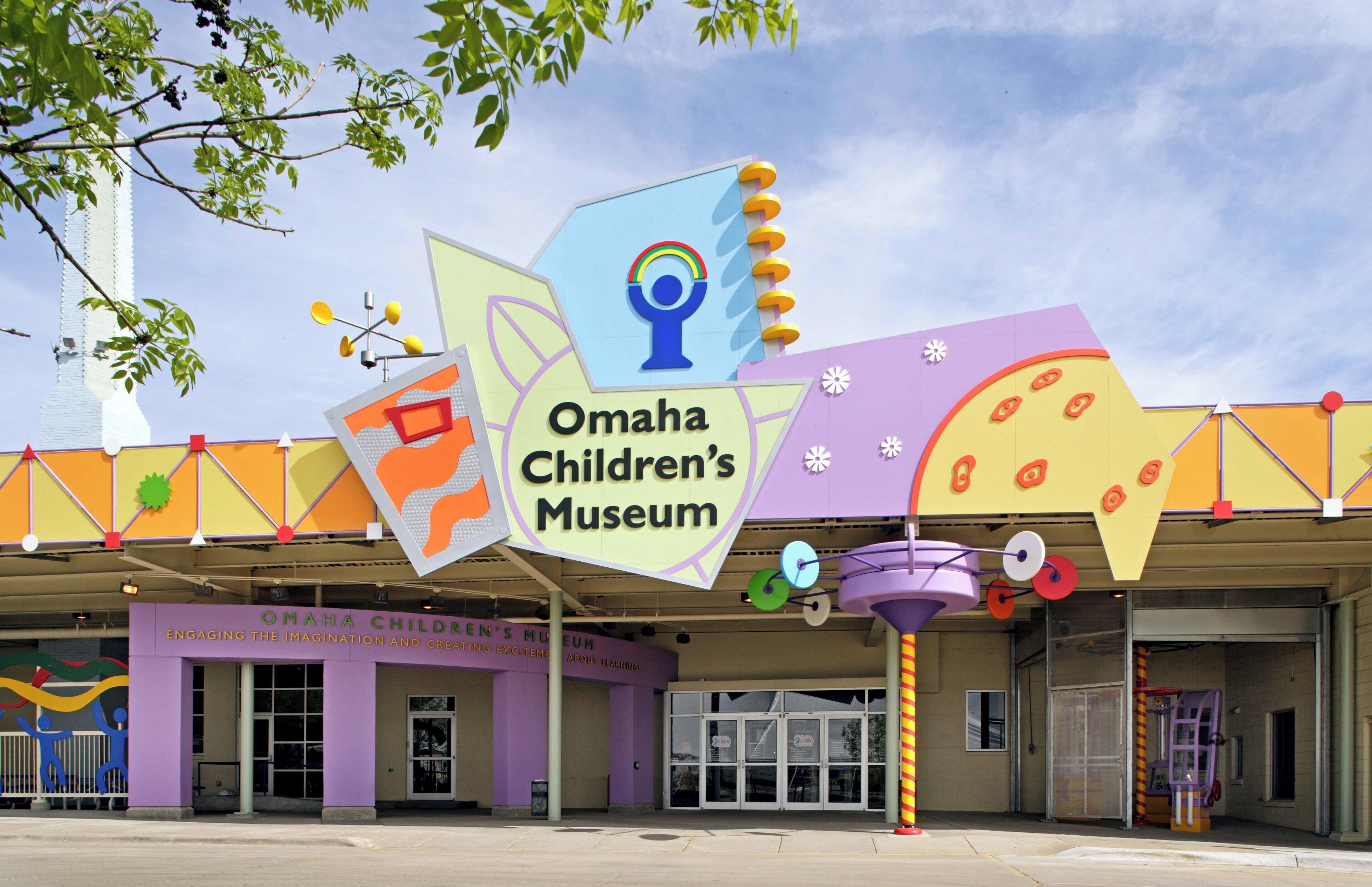 The exterior of the Omaha Children's Museum with a colorful sign and a purple entrance.