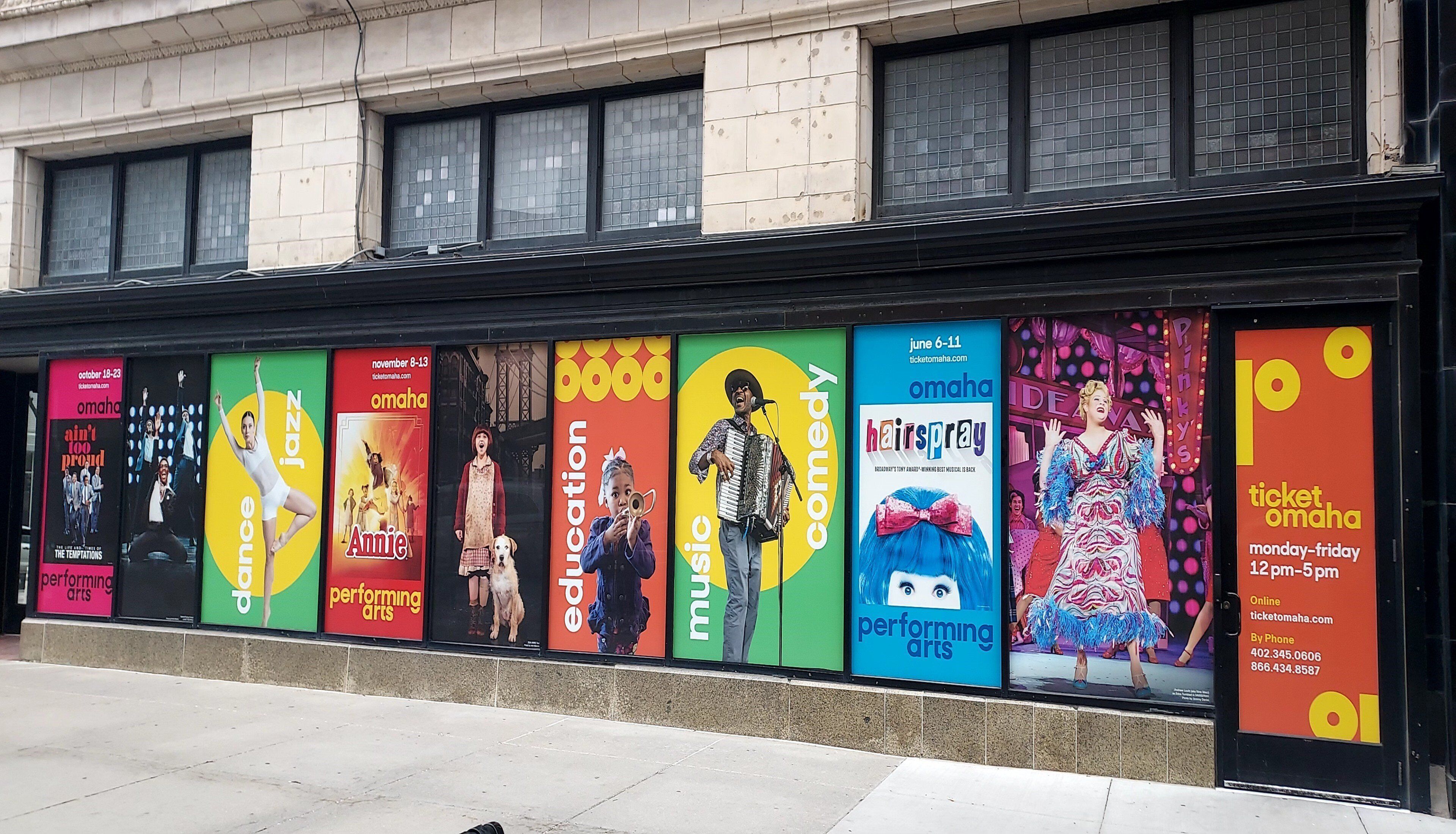 A series of colorful posters advertising various performing arts events at a theater.